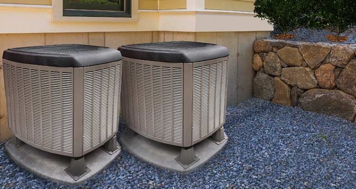 Two heat pump units outside a home.